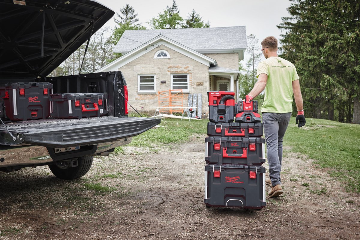 Pracownik ciągnie wózek PACKOUT z ładowarką PC6 do samochodu