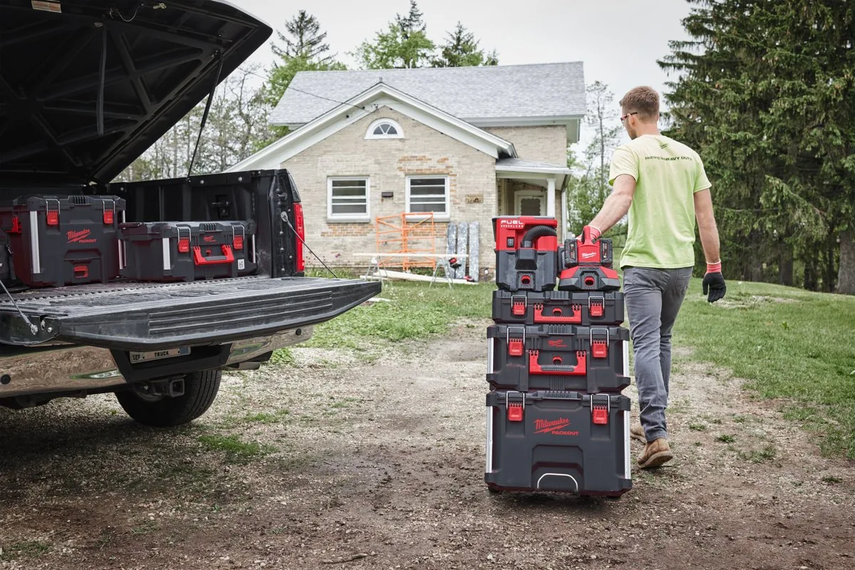 Pracownik ciągnie wózek PACKOUT z ładowarką PC6 do samochodu