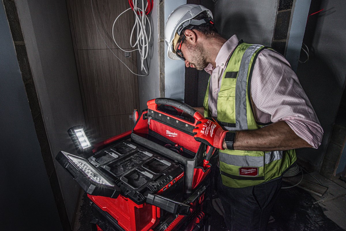 Elektryk przy lampie M18 POALC w ciemnym korytarzu