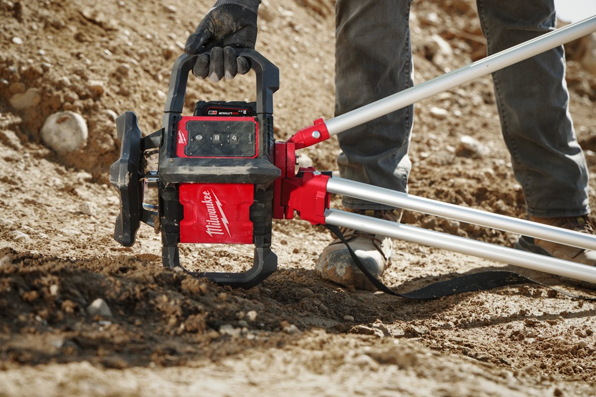 Monter wbija statyw z niwelatorem M18 RLOH600 w grunt