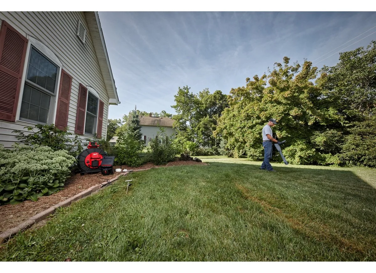 Bęben M18 SIC60 HDR przy domu, operator lokalizuje trasę rury w ogrodzie
