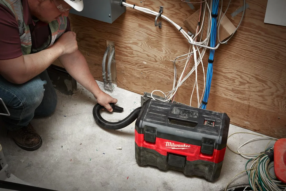 Elektryk odkurza przy instalacji elektrycznej