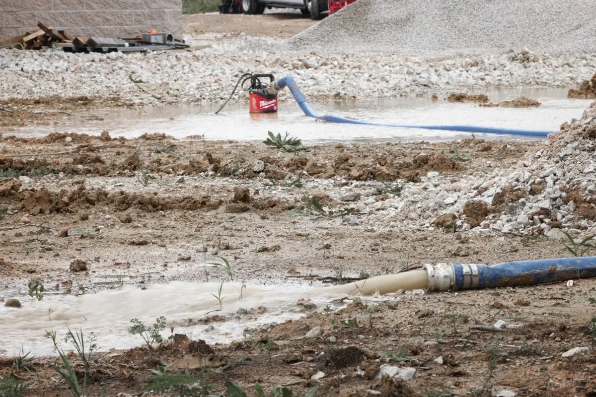 Jednostka zatapialna MX FUEL w kałuży na placu budowy z wężem