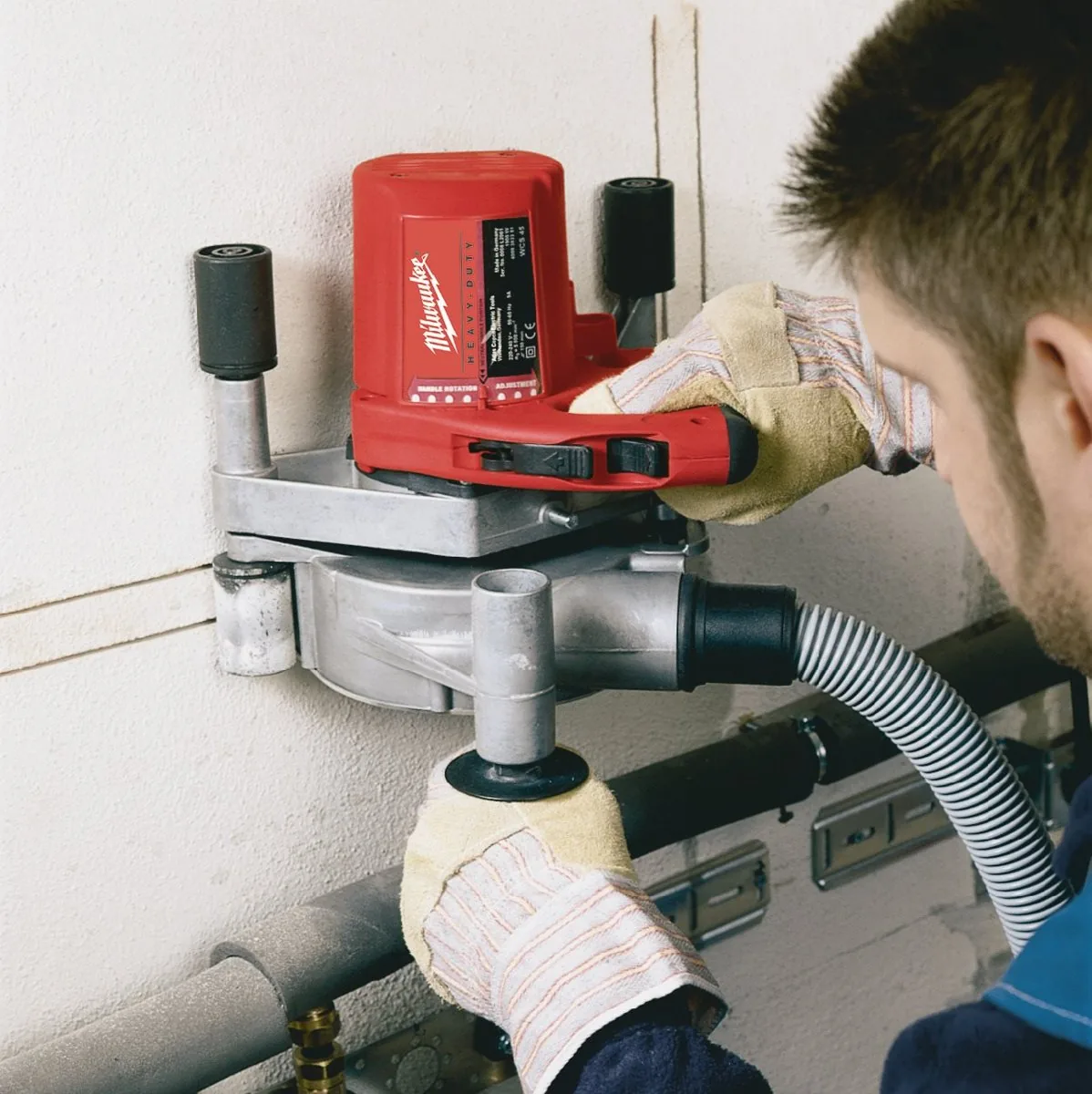 Instalator tnie bruzdę w ścianie bruzdownicą WCS 45 z odkurzaczem
