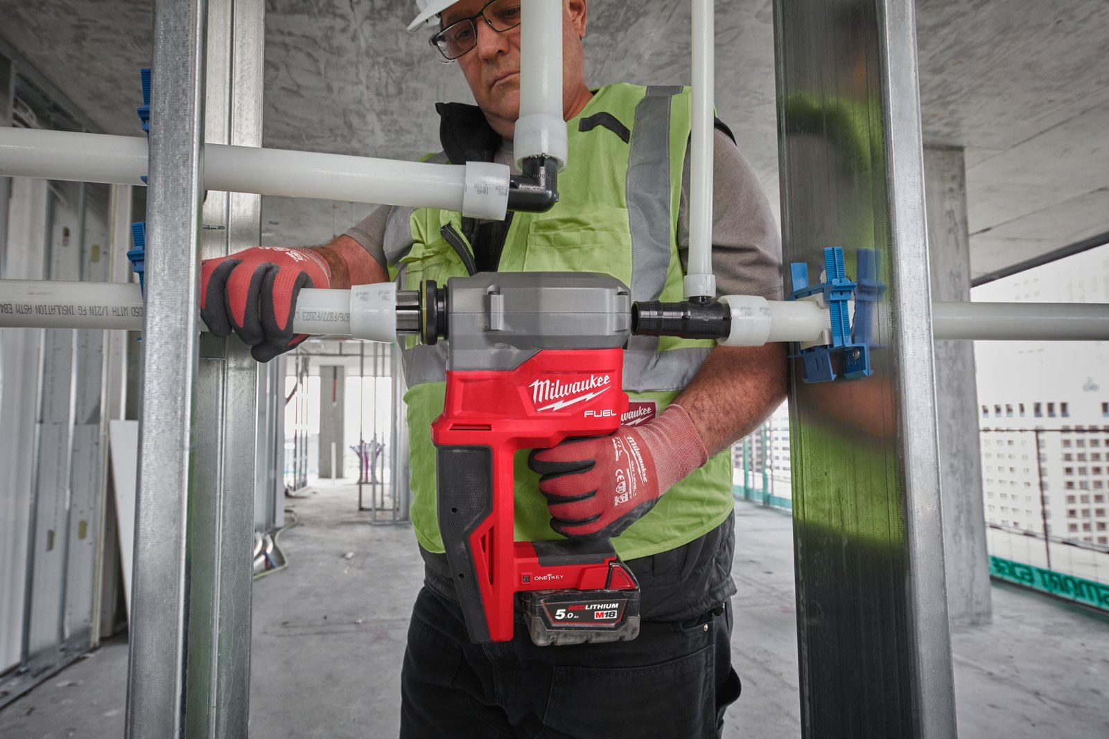 Instalator rozszerza rurę PEX narzędziem M18 FPXP przy pionie instalacyjnym