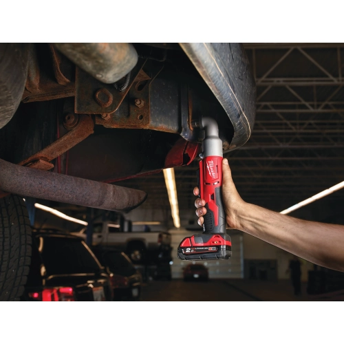 Mechanik dokręca Milwaukee M18 BRAIW nakrętkę pod podwoziem ciężarówki
