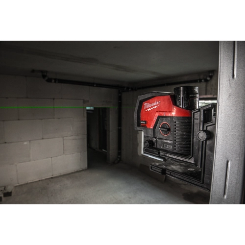 Laser Milwaukee M12 CLLP na wsporniku przy ścianie w pomieszczeniu technicznym