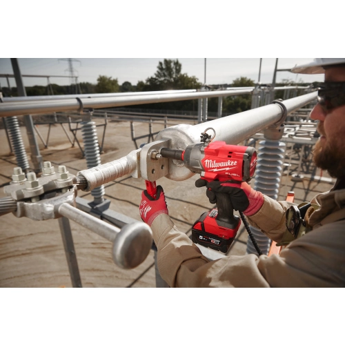 Monter dokręca Milwaukee M18 FHIW2P12 połączenia na stacji energetycznej