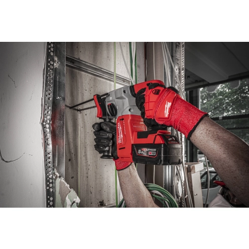 Milwaukee M18 BLH wierci w otynkowanej ścianie obok wyprowadzonych kabli