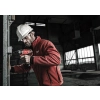Elektryk w kasku wkręca Milwaukee M12 CD w rozdzielni na ścianie hali