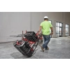 Wózek transportowy Milwaukee PACKOUT 180 kg – Pracownik przewozi skrzynie na wózku PACKOUT przez halę